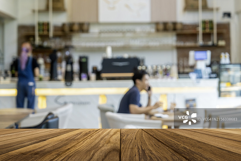 咖啡店或餐厅背景中人流模糊的木桌面图片素材