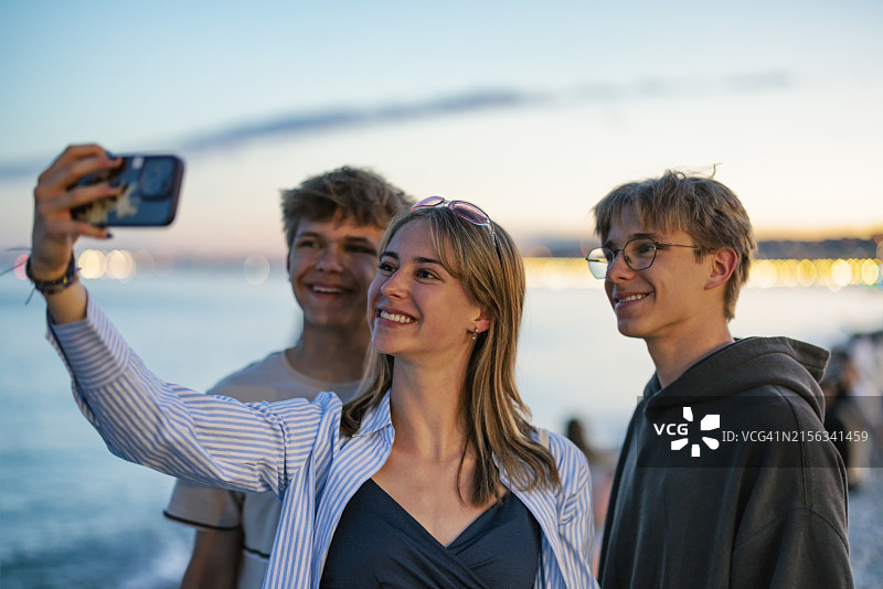 在法国尼斯海滩自拍的青少年图片素材