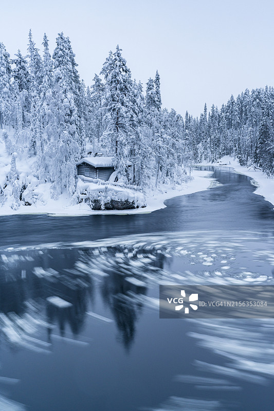 冰冻河流岸边的雪 forest 和小屋图片素材