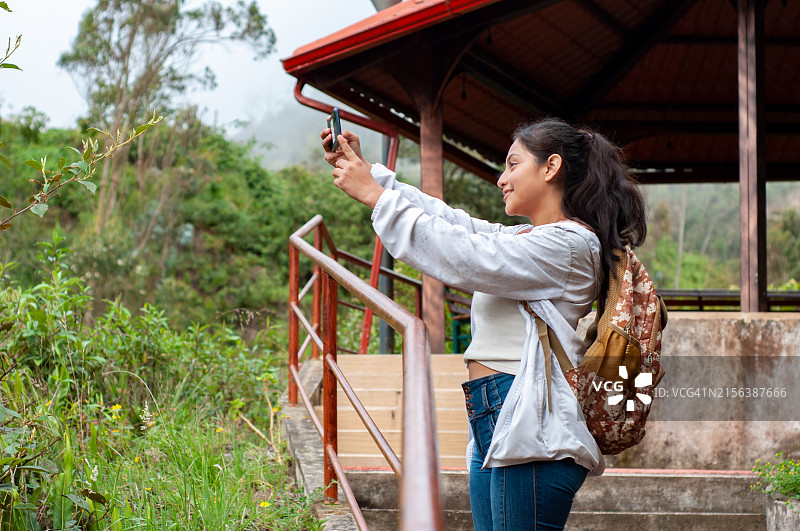 在旅游景点拍照的年轻游客图片素材