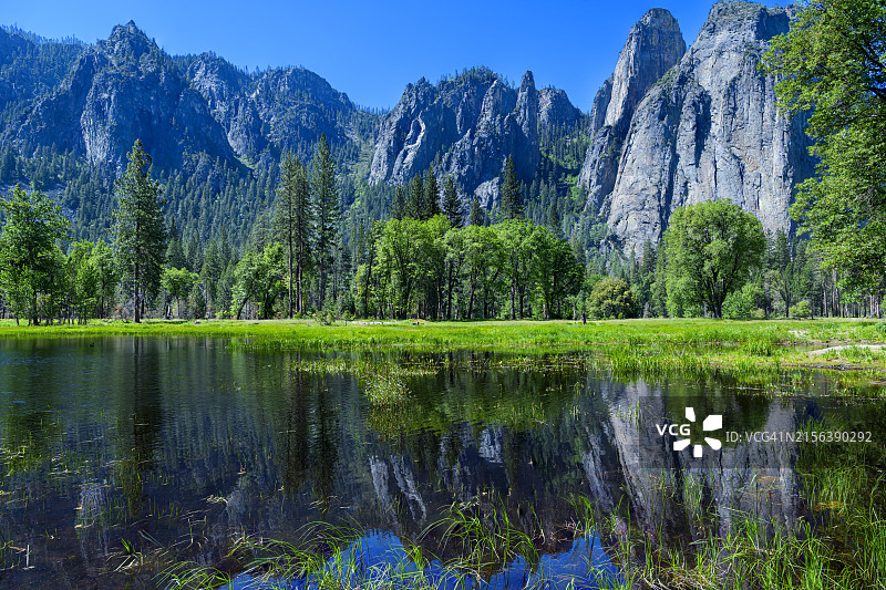 草地池塘中倒映的大教堂尖顶图片素材