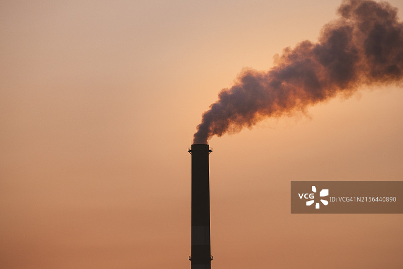 日落时分，澳大利亚昆士兰州伊萨山大气污染的烟囱图片素材