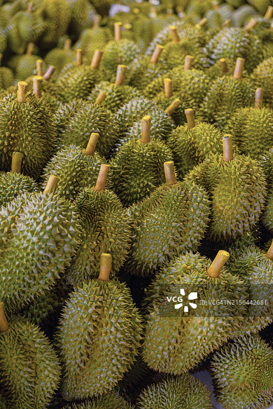 热闹的亚洲市场：东南亚市场摊位上的堆叠榴莲图片素材