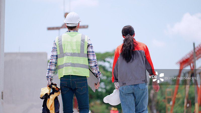 建筑承包商或工程师在建筑工地准备工作背面拍摄图片素材