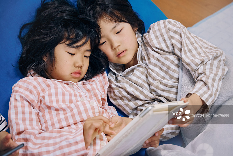 早上使用智能手机和平板电脑的儿童图片素材