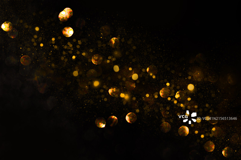 深色背景上的金色模糊粒子图片素材