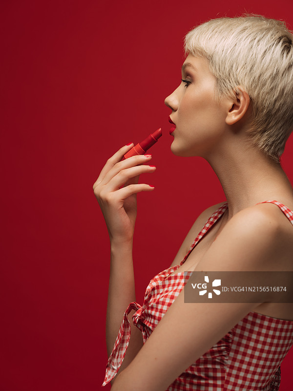 女士涂抹红色口红的肖像图片素材