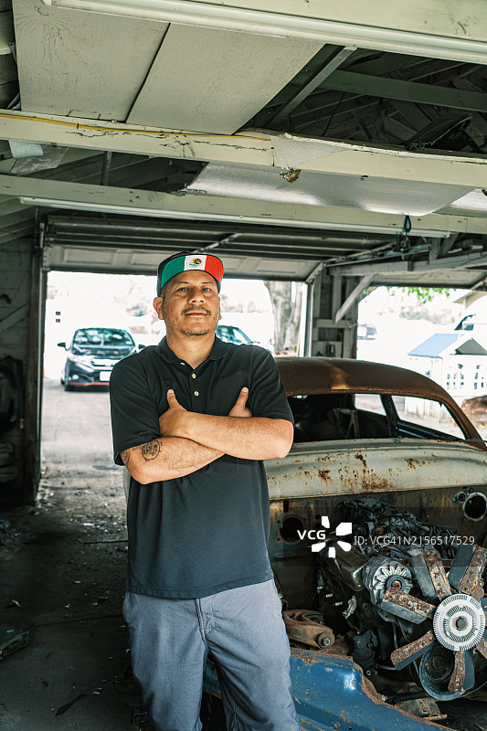 中年拉丁裔男性商家在车库与老爷车项目图片素材