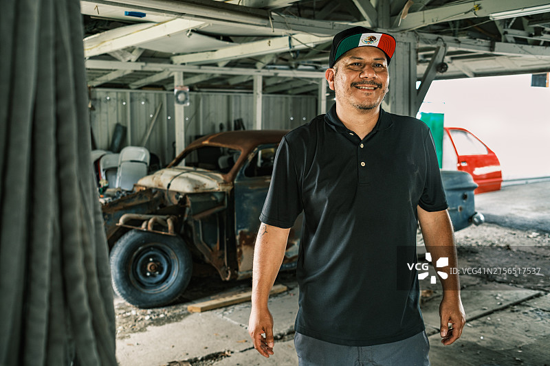 中年拉丁裔男性商家在车库与老爷车项目图片素材