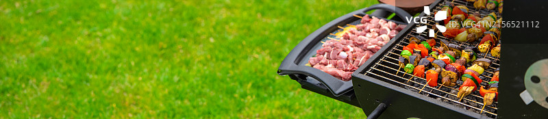 男子在烧烤架上准备食物的腰部特写图片素材