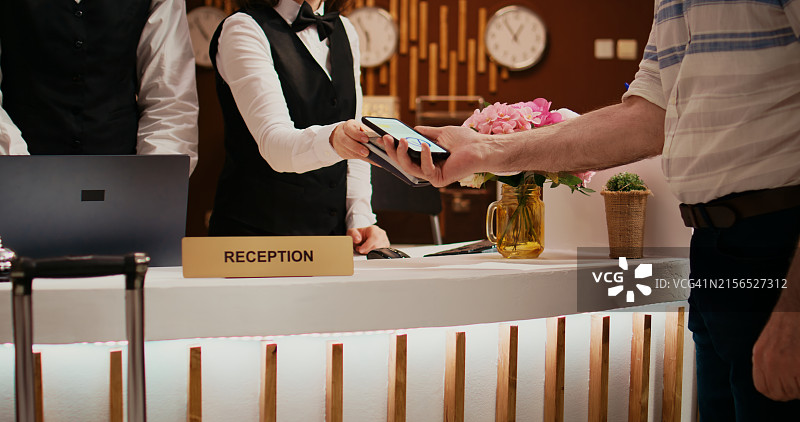 男人在商店向售货员出示信用卡的腰部特写图片素材