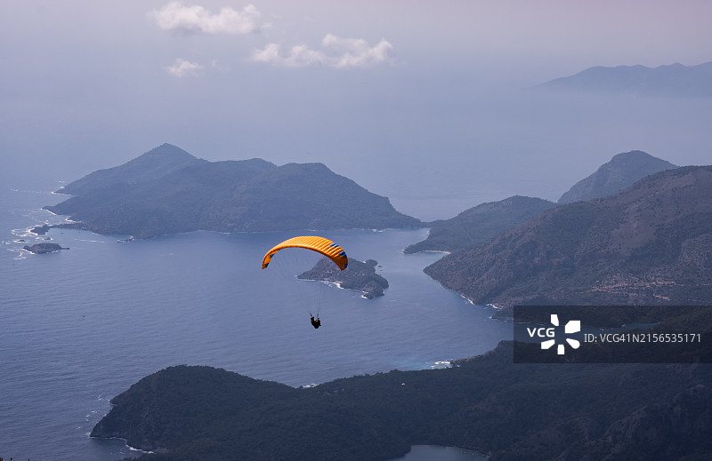 男人在海上玩滑翔伞，以天空为背景图片素材