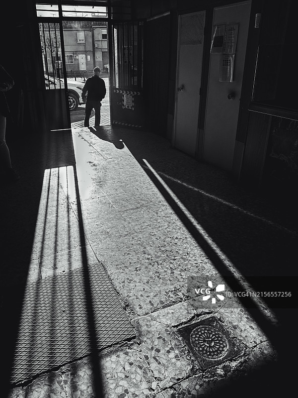 一位老人买了一些油条当早餐后离开购物街图片素材