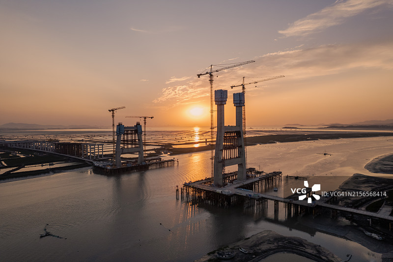 日出时泥滩上的红树林和在建的海上跨海大桥航拍图片素材