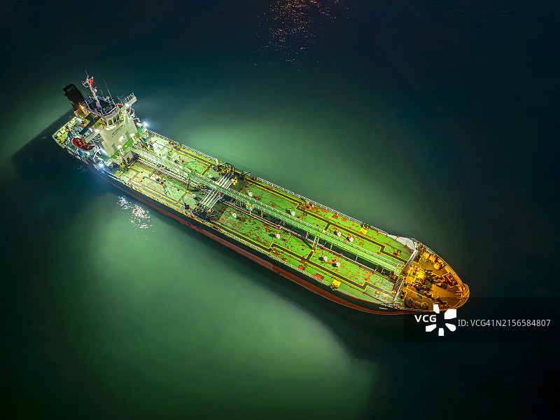 停靠在海边海湾的绿色油轮航拍夜景，等待运往炼油厂图片素材
