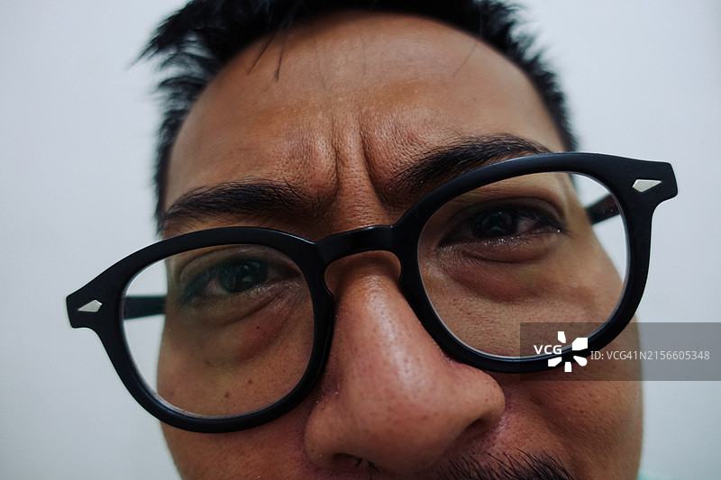 戴着大眼镜的亚洲年轻男人的有趣面孔图片素材