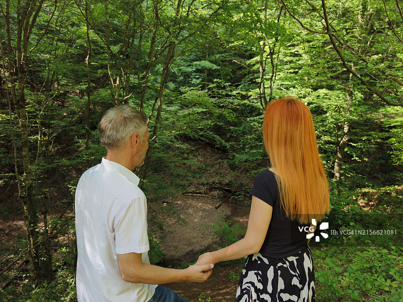 异性恋夫妇在树林里散步放松图片素材