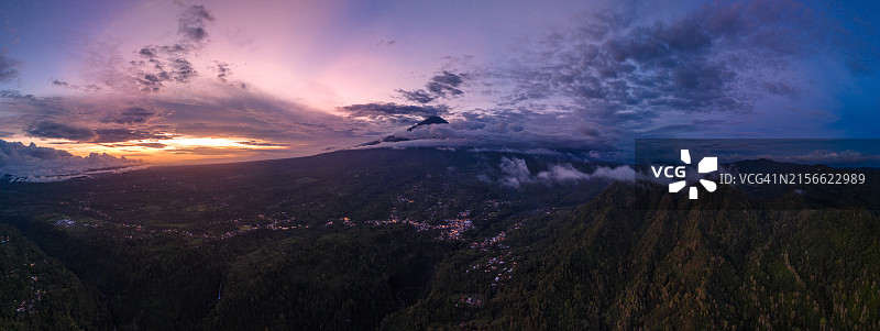 日出日落时分绿意环绕的塞梅鲁火山瀑布全景图片素材