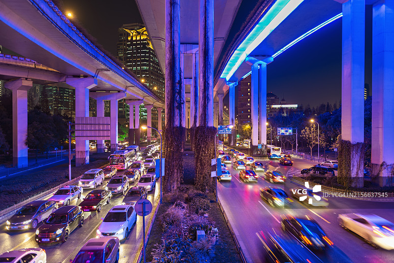 上海市中心夜晚的道路交叉口与霓虹灯光，交通繁忙图片素材