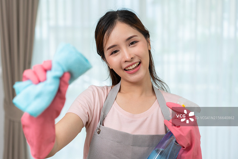 微笑的女人用抹布和喷雾清洁图片素材