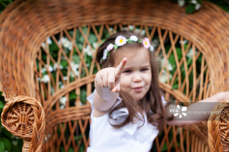 戴着花朵头饰的女孩，背景是开花的树图片素材