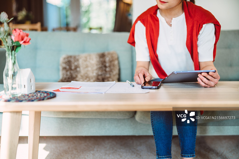 在家使用AI金融App理财的年轻亚洲女性图片素材