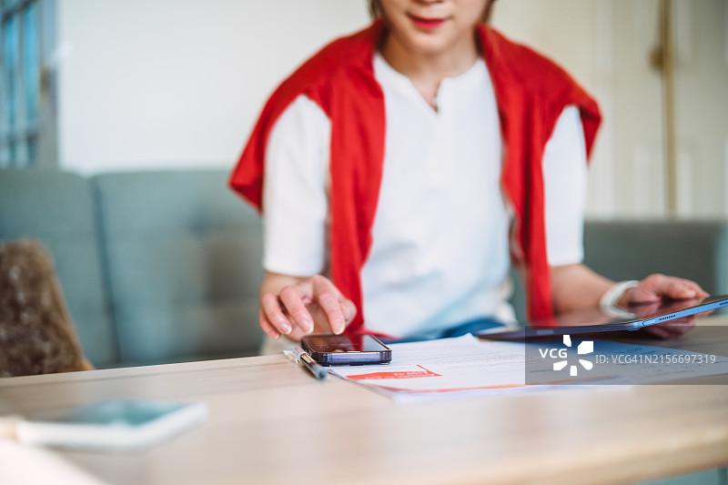 在家使用AI金融App理财的年轻亚洲女性图片素材