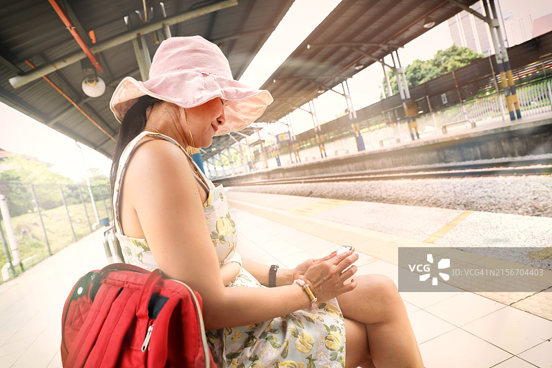 在火车站的快乐亚洲年轻女性图片素材