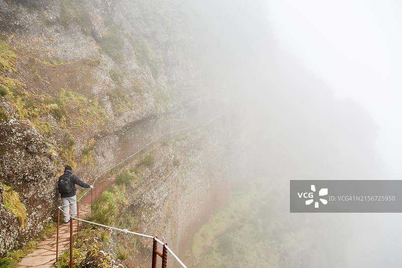徒步旅行者沿着的悬崖行走图片素材