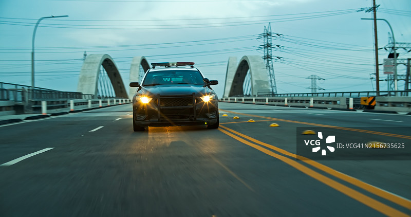 傍晚时分，警车行驶在洛杉矶市中心第六街桥上图片素材