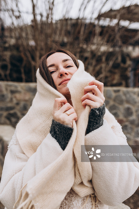在冬季户外穿着白色保暖衣服散步的年轻女子肖像图片素材