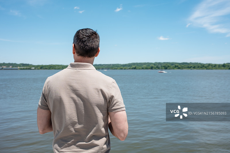 男人在海滨享受阳光明媚的一天图片素材