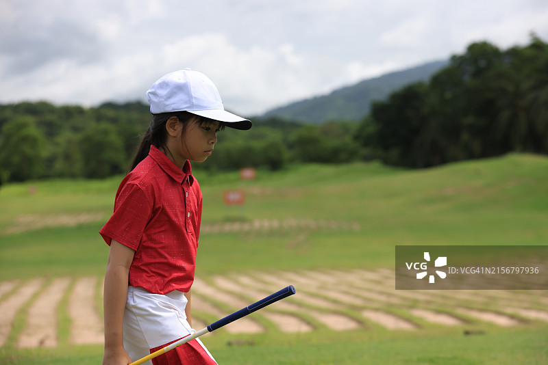 小女孩在球场练习高尔夫球图片素材