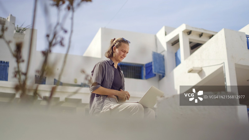 年轻女人在乡村使用笔记本电脑图片素材