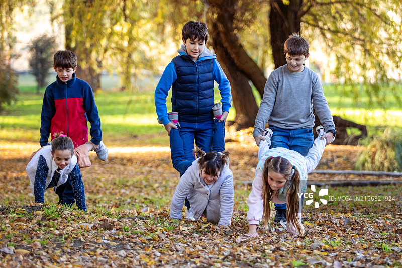 快乐的孩子们玩推车比赛图片素材