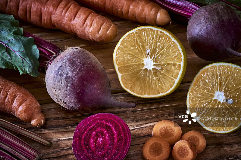准备烹饪的木板上的胡萝卜、甜菜根和橙子图片素材
