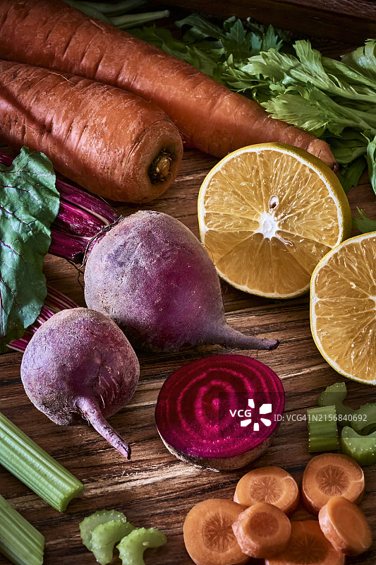准备烹饪的木板上的胡萝卜、甜菜根和橙子图片素材