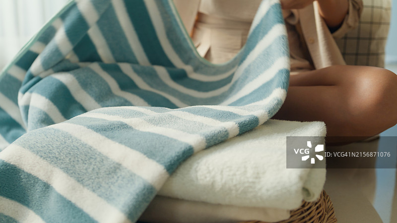 美丽的年轻亚洲女人在家洗衣服的特写。家中的日常生活活动图片素材