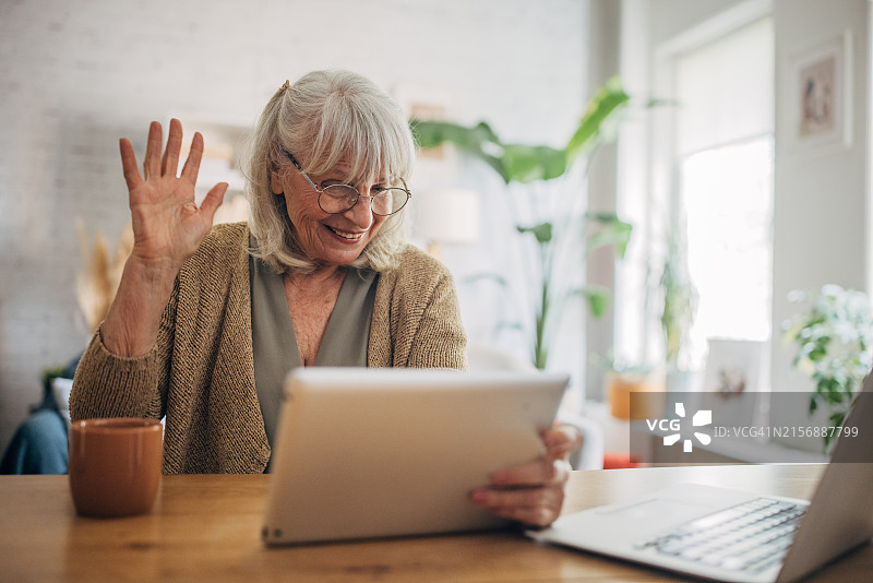 老年白人妇女使用平板电脑进行视频聊天图片素材