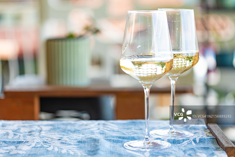 露台上椅子旁的白葡萄酒杯图片素材