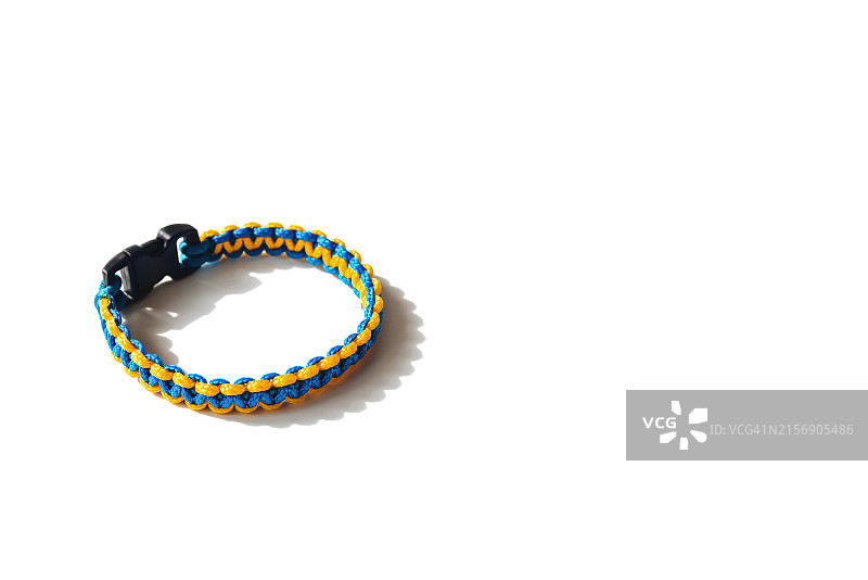 白色背景上的蓝黄色编织伞绳手链图片素材