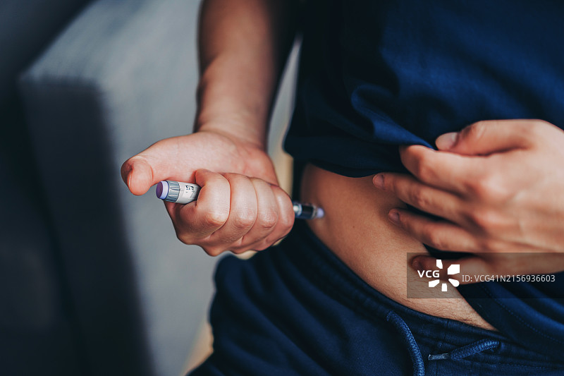 年轻男人在家中注射胰岛素图片素材