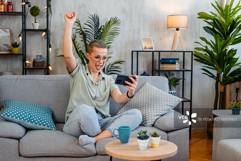 中年妇女在平板电脑上看体育比赛，为她的球队加油图片素材