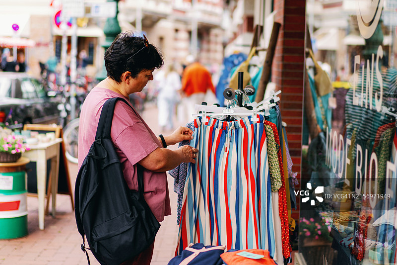 女人在服装店购物。促销季。季节性购物图片素材