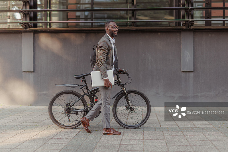 年轻商人骑自行车穿梭城市街景图片素材
