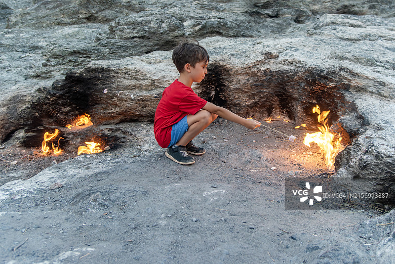 男孩特写：在火上烤棉花糖，奇美拉山，土耳其安塔利亚图片素材