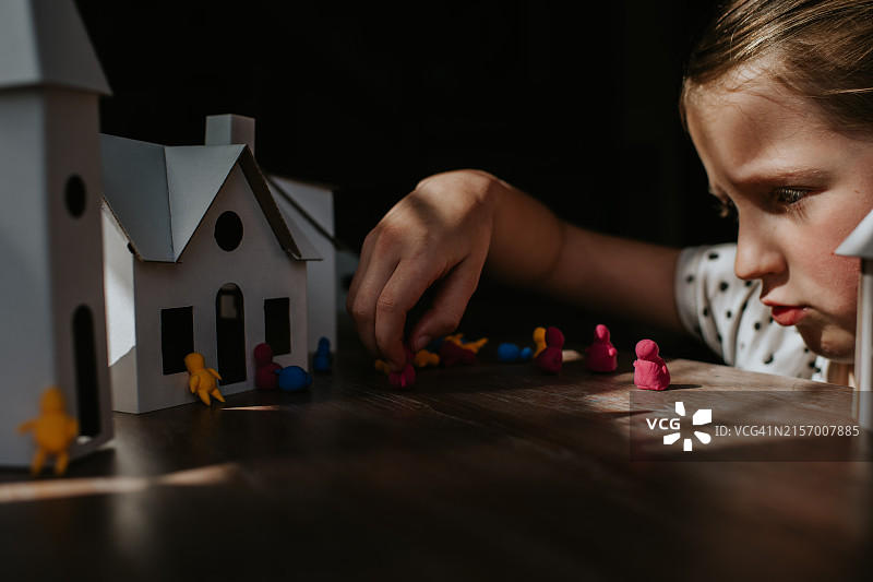 玩小人偶和纸板房子的小女孩图片素材