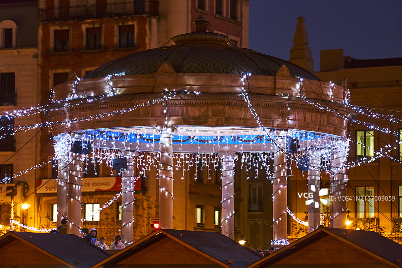潘普洛纳市政厅的正面外观，夜间有圣诞灯饰和人群图片素材