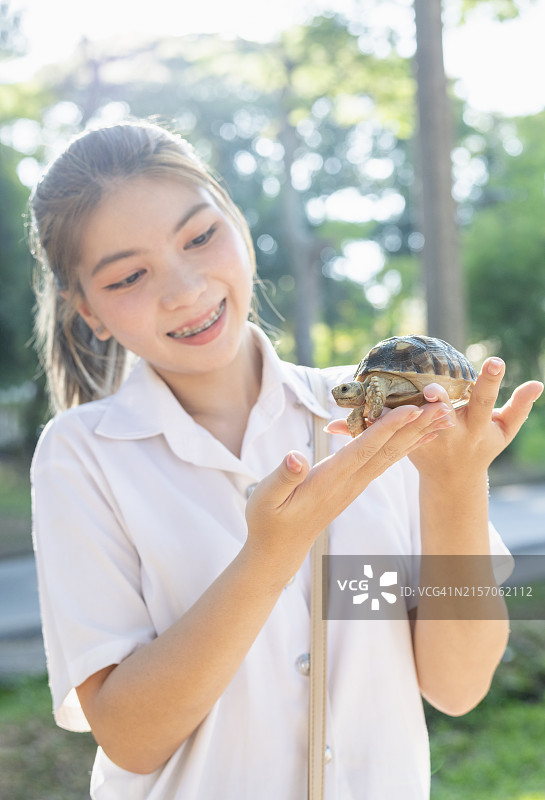 年轻女学生抱着乌龟图片素材