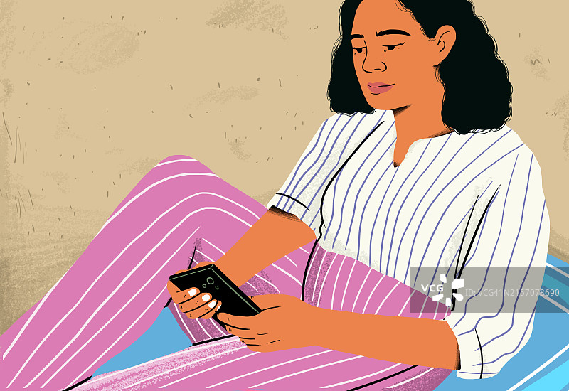 坐在海滩上使用智能手机的女人图片素材